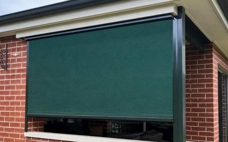 Charcoal verandah blind installed against red brick home exterior