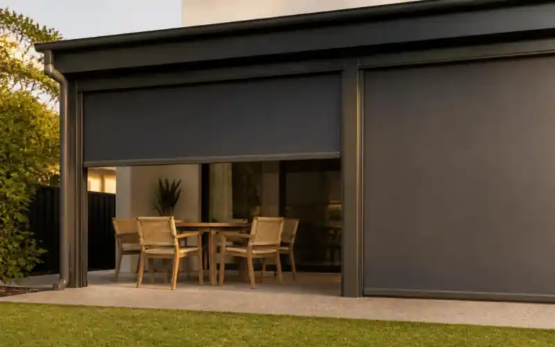 Outdoor blind partly lowered over an alfresco dining area