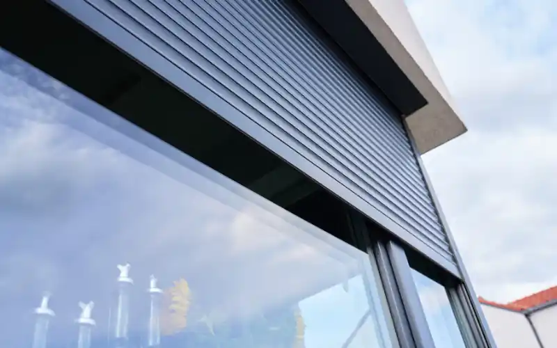 Roller shutter partly open above a window